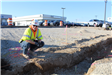 A construction worker inspecting a drainage trench on Sagamore Parkway